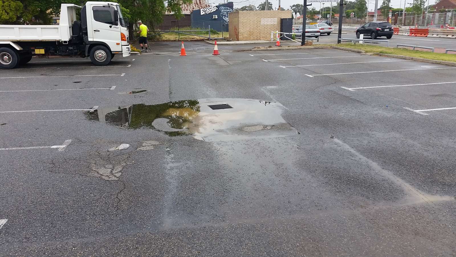 Before image of the queens park car park in Perth in need of a commercial car park repair with potholes and drainage issues causing pools of water