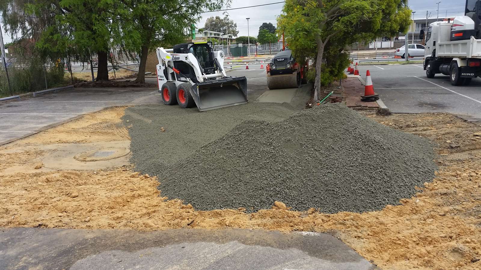 Fresh asphalt roadbase applied for commercial car park repair in queens park by Perth's leading asphalt contractors NK asphalt featuring heavy machinery.