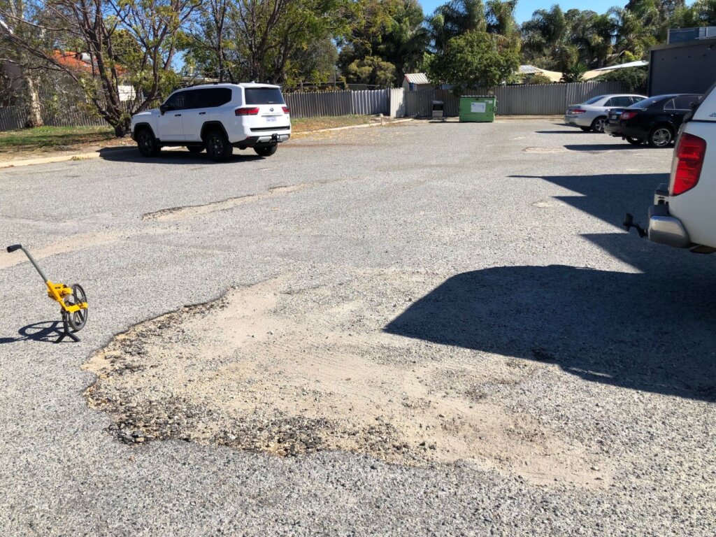 Pot hole in need of repairs at an asphalt commercial asphalt car park in Koongamia, Perth WA. 